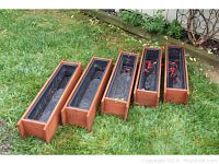 Five cedar window boxes with black plastic inserts arranged on grass, showing overall quantity and condition.