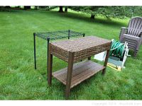 Outdoor wicker table with wooden legs and metal wire rack table side by side on grass, showing overall view and condition
