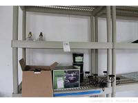 Photo showing cardboard box, Smith and Hawken ceramic flame pots, citronella candles, and metal tea light holder on shelving in garage.