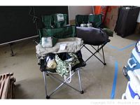 Three folding camping chairs with green fabric, two branded North Point, along with other camping items stacked on one chair
