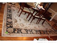 Overall view of wool area rug under dining table on hardwood floor