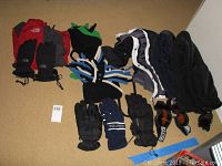 Photo shows four pairs of gloves laid out including The North Face, Nautica, and Dakine brands, black and blue colors.