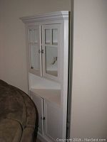 Side angle showing glass-paneled upper doors, middle open shelf, lower solid doors, and stainless hardware.