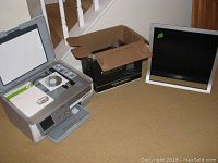 HP Photosmart C8100 all-in-one printer, assorted PC software programs in a box, and Sony 18-inch monitor on the floor near stairs and wooden door.