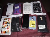 View of 9 assorted phone cases, some still in packaging, showing various colors and patterns.