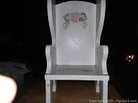 Front angled view of white wooden chair with pink rose floral artwork on backrest and seat.