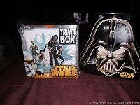 Star Wars Trivia Box game and Darth Vader tin container displayed together on a table with dark cloth