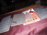 Top view of several folio-style smartphone cases in fabric textures and different shades, showing front covers, card slots, and packaging.