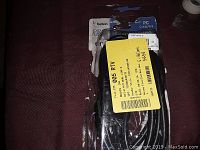 Belkin digital video dual link cable in original packaging on a dark fabric surface, packaging has yellow labeling sticker from prior inventory or auction.