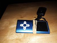 Blue Trio portable MP3 player with white control buttons and black screen, not tested, with black attached cord held by rubber band.