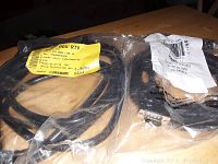 Photo of sealed cables on wooden surface with Belkin 005-RTV label visible on one package