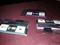 Two Nano-Fix finger trigger relievers in original packaging on a dark surface.