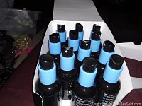 Photo showing 12 bottles of Funk Away odor eliminating spray with blue spray tops in a partially open box.