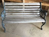 Frontal view of the bench indoors showing full structure and wood slats.