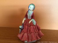 Front view of the Paragon Lady Gwendoline figurine showing detailed facial features, red dress with layers, and bonnet.