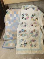 Two vintage quilts draped side by side showing overall condition and pattern differences
