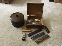 Top-down shot of the lot items arranged on carpet: wooden box open with lighters inside, brown metal container, razor blade boxes, and one Swing Band harmonica tin.