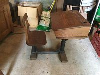 Side view of the vintage wooden school desk showing attached chair and metal base.