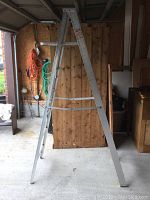Full view of the 7 foot aluminum step ladder fully extended in A-frame position inside a garage environment showing overall condition.