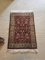 Full view of the handmade wool rug showing its pattern, border, and fringe.