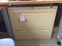 Front view of the beige two drawer lateral file cabinet under desk