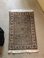 Full view of the rectangular wool rug showing pattern and fringe.
