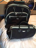 Wheeled luggage and handbag set displayed together on bed, showing front and side views.