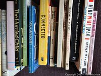 Books displayed on shelf, covers facing forward showing titles related to self-help, coaching, mindfulness, and psychology.