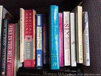 Photo of 11 books showing titles related to self-help, mindfulness, and some fiction, arranged on a dark surface.