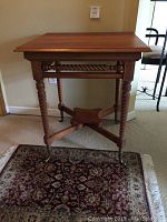 Full view of the whole wooden table showing barley twist legs and carved apron.
