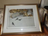 Framed Bateman print depicting four birds near stacked logs on a snowy or light ground, signed lower right corner, with light wood frame and white mat.