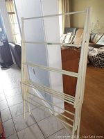 Full view of the wood drying rack in open position showing frame and horizontal drying bars.