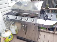 Front view of grill showing control panel, side shelf and included propane tanks