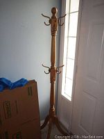 Full view of wooden coat rack showing height and base.