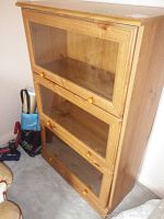 Front view of the three-tier barristers style bookcase with glass-front compartments and wooden knobs.