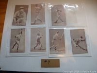 Photo showing 8 vintage baseball player cards in protective sleeves, some with handwritten player names, black and white images, players in various action and portrait poses.
