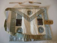 Full view of vintage Mason Masonic apron with attached straps and decorative rosettes and chains.