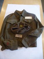 Full view of olive drab wool tunic laid out under matching cap