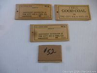 Photo of three vintage ice coupons and a small price tag. Visible distributor numbers and text indicating 500 lbs ice coupon books from City Ice & Fuel Co.