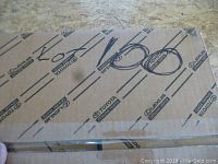 Photo of sealed cardboard box with Toyota and Lexus branding, labeled 'Lot 100'