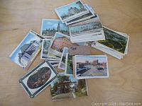 Top-down view of multiple vintage postcards spread on a wooden table, showing colorized images of old buildings and landscapes in Ontario, Canada, circa 1930s and 40s.
