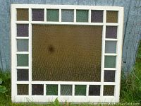 Front view, white-painted wood frame with central amber textured pane and border squares