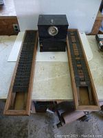 Image showing the IBM punch clock centered between two oak time card holders on a table surface.
