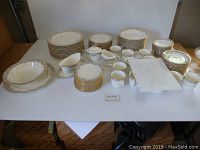 Full overview of arranged china set showing plates, cups, and serving pieces.