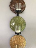 Wall-mounted multicolored metal circular disc candle holder with five glass tea-light holders, shown in various angles and full view