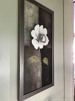 Front view of framed original acrylic painting of a white flower on canvas with an abstract dark background.