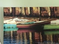 Full view of canvas print depicting boats at dock with pier wall background and water reflections.