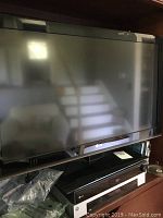 LG flat screen TV and LG DVD player stacked below it inside a shelf