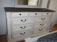 Front view of dresser showing nine drawers, dark wood top and white finish