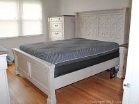 Assembled queen bed frame and mattress in bedroom